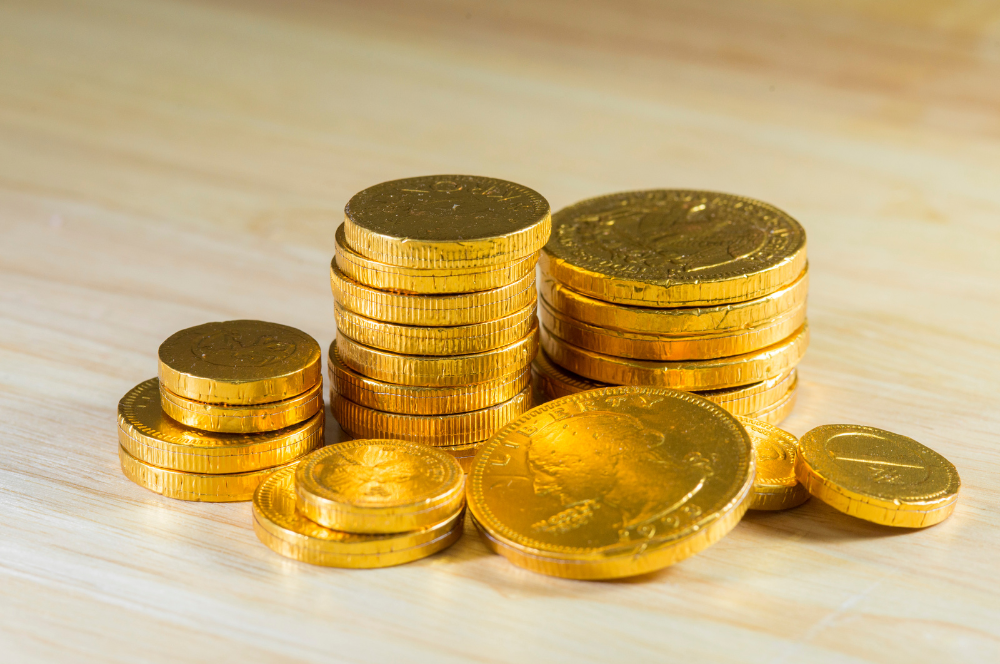 Stacks of shiny gold coins on a wooden surface – reliable Coin Buyers in Lubbock offering fair prices.